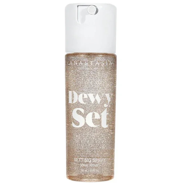 Dewy Set setting spray with glittery liquid in a clear spray bottle and white cap