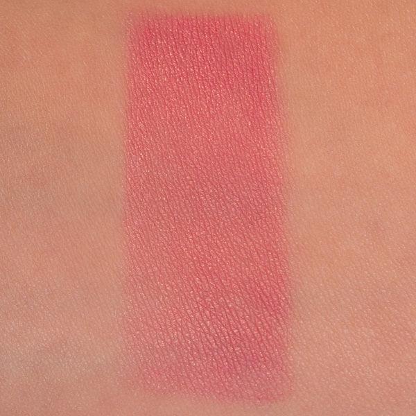 Pink powder blush swatch on skin, soft silky matte finish, makeup texture close-up