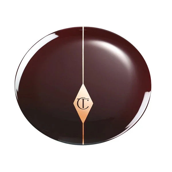 Closed round brown compact with gold accent and CT monogram, makeup packaging