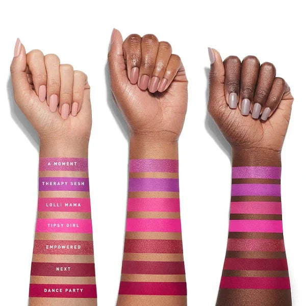 Three arms with swatches of pink and purple eyeshadow shades on varying skin tones.